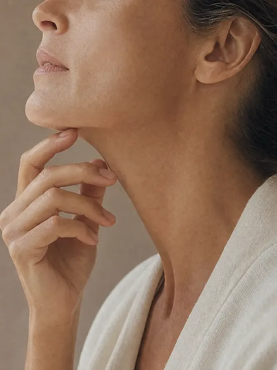 Femme de profil, la main sous le menton, ovale du visage et cou dégagés