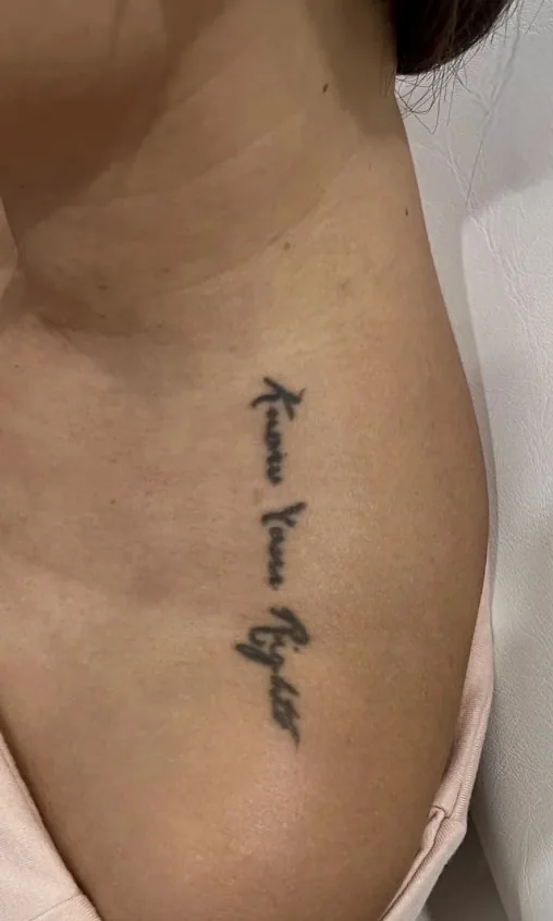 Tatouage manuscrit noir sur le décolleté d'une femme, avant le détatouage laser chez My Laser Casablanca